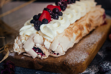 Meringue roll with berries. Delicious meringue roll on the table 