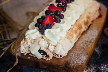 Meringue roll with berries. Delicious meringue roll on the table 