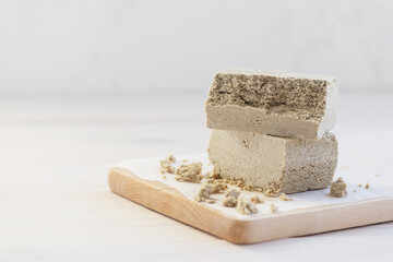 Halva pieces on a wooden board. Horizontal orientation, copy space.