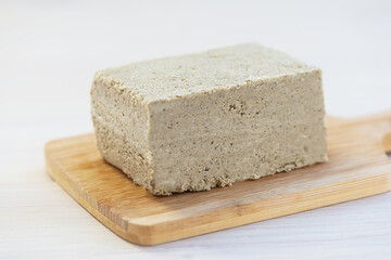Piece of halva on a wooden board, horizontal orientation. 