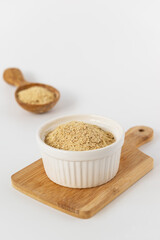 Vegan yeast in a bowl on a white background.