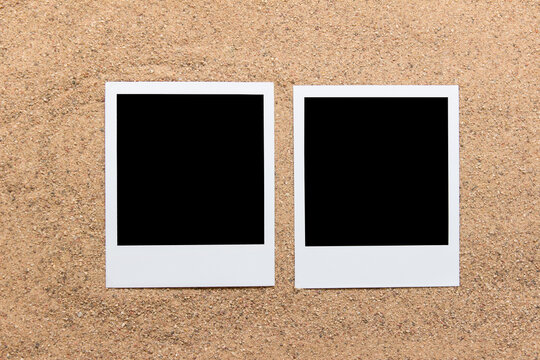 Two polaroid photos on real sand with little grains visible.