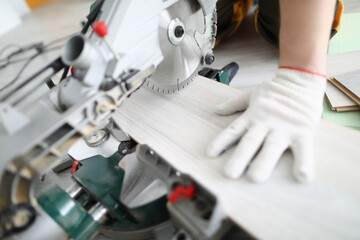 Master of flooring cuts daughter of the laminate on hand-held circular saw