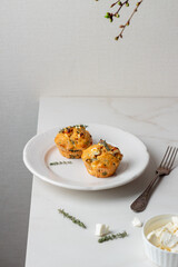 Spinach Feta cheese breakfast muffins on a plate. White marble background.