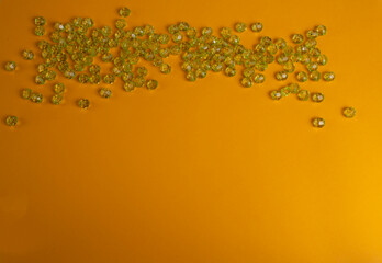 Green plastic beads on a yellow background.