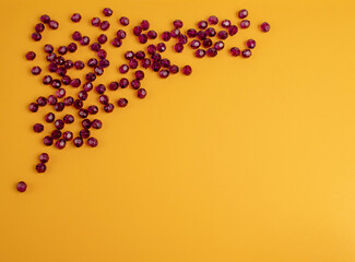 purple plastic beads on a yellow background.