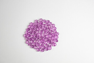 purple plastic beads on a white, gray background.