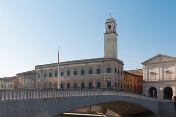 Obraz premium View of Pisa: Palazzo Pretorio (praetorium palace) seat of the town hall of the city and Ponte di Mezzo (middle bridge) on the banks of the Arno river