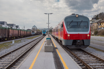Fototapeta premium Old versus new passenger train standing on a platform. Concept of modernisation of rolling stock on railways.