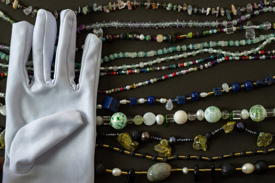 White Glove With Jewelry On A Dark Background.Flat Lay.