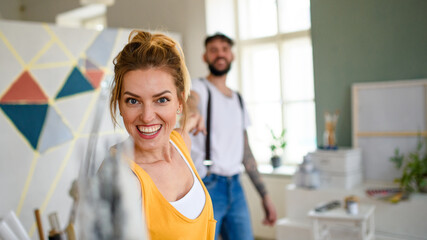 Couple having fun when painting wall indoors at home, relocation and diy concept.