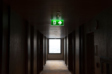 Illuminated green light emergency exit sign in public building for emergency accident and fire...