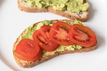 Toast with crushed avocado and tomato, vegan breakfast