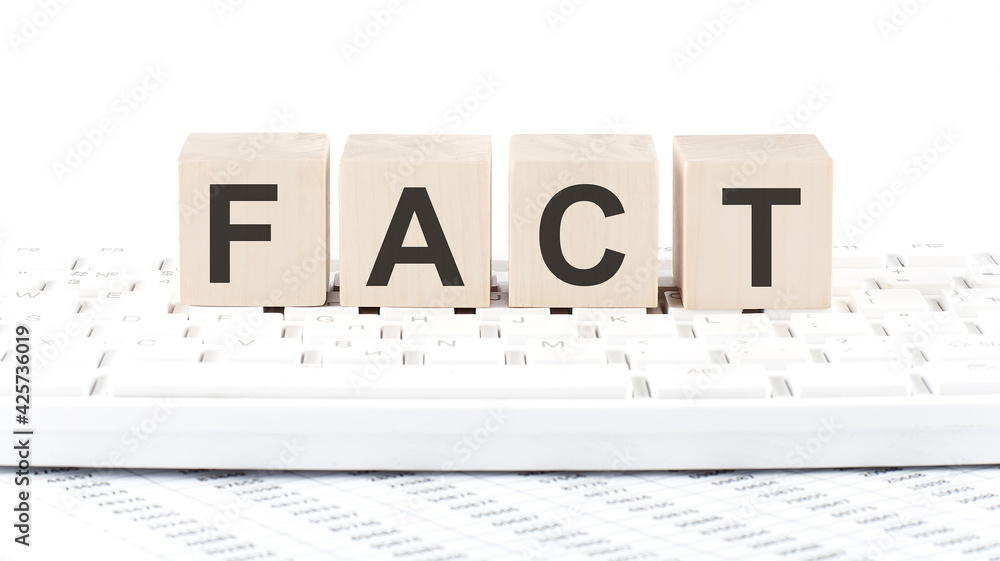 Poster fact -word wooden block on the keyboard background witn chart