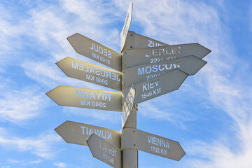 White metal signpost with names of capital cities at the summit of Tahtali mountain. Kemer, Turkey