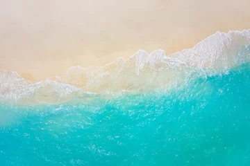 Fotobehang Top view on coast waves on beach aerial view, crystal clear water. Stunning summer landscape, sunny tropical island shore. Seaside, idyllic nature Earth view. Stunning scenery, amazing view © icemanphotos