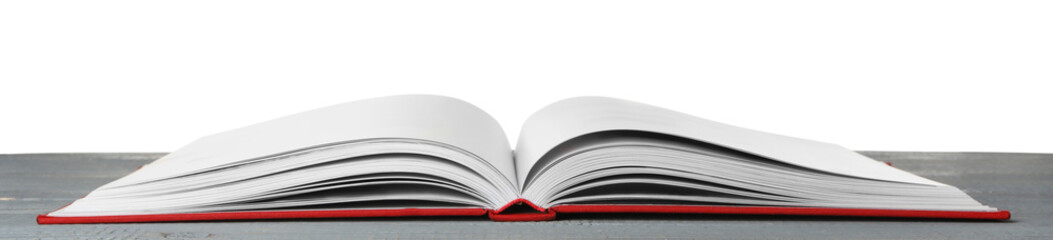 Open book with red cover on wooden table against white background