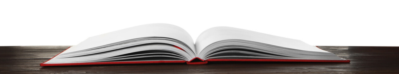 Open book with red cover on wooden table against white background