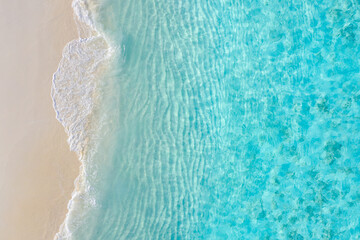 Fototapeta na wymiar Top view on coast waves on beach aerial view, crystal clear water. Stunning summer landscape, sunny tropical island shore. Seaside, idyllic nature Earth view. Stunning scenery, amazing view