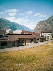 Fototapeta na wymiar Abandoned factory front view in the valley. Glimpse of Biasca in Switzerland