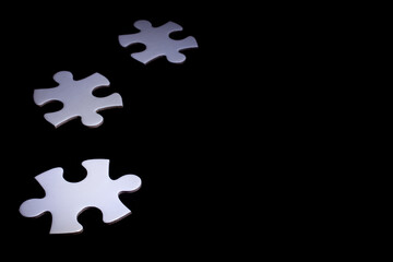 White details of puzzle on black background. With copy space