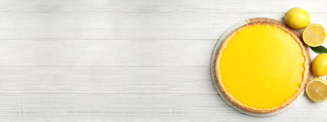 Delicious homemade lemon pie and fruits on white wooden table, flat lay. Space for text