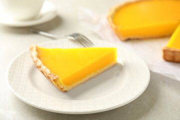 Slice of delicious homemade lemon pie on light grey table