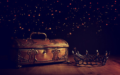 low key image of beautiful queen or king crown over gold treasure chest. vintage filtered. fantasy...