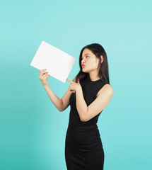 Blank empty paper in teenage girl or woman's hand on green or Tiffany Blue background.she wear black dress