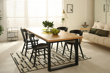 Stylish wooden dining table and chairs in room. Interior design