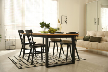 Stylish wooden dining table and chairs in room. Interior design