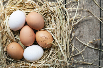 Organic eggs in nest on wooden background.	
