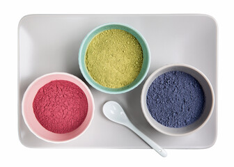 Green, red and blue matcha tea powder in bowls isolated on white.