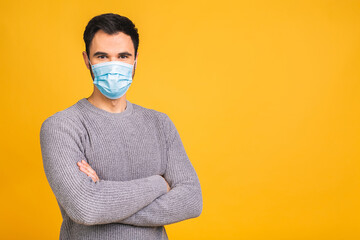 Protection against contagious disease, coronavirus, covid-19. Man wearing hygienic mask to prevent infection, airborne respiratory illness such as flu, 2019-nCoV. Isolated over yellow background