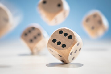 Throwing and rolling wooden dice on a blue background