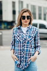 Fashion portrait of beautiful woman with beautiful face, wearing grunge plaid shirt. Posing alone.