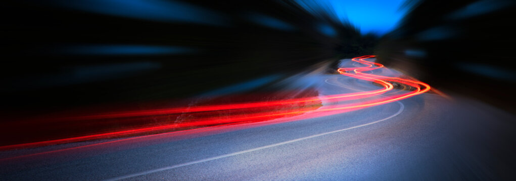 Panoramic - Cars light trails at night in a curve road