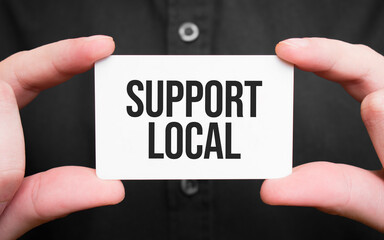 Businessman holding a card with text support local,business concept