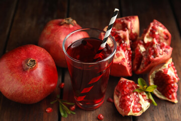 Pomegranate juice and fresh fruits on wooden table