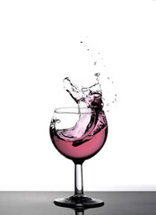 a big splash of red drink in a glass