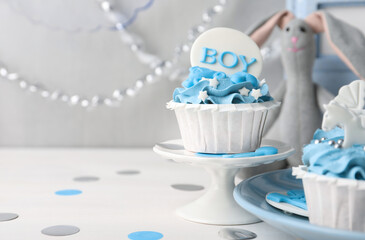 Delicious cupcake with light blue cream and Boy topper on white wooden table, space for text. Baby shower party