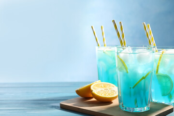 Delicious refreshing cocktail with ice on wooden table. Space for text