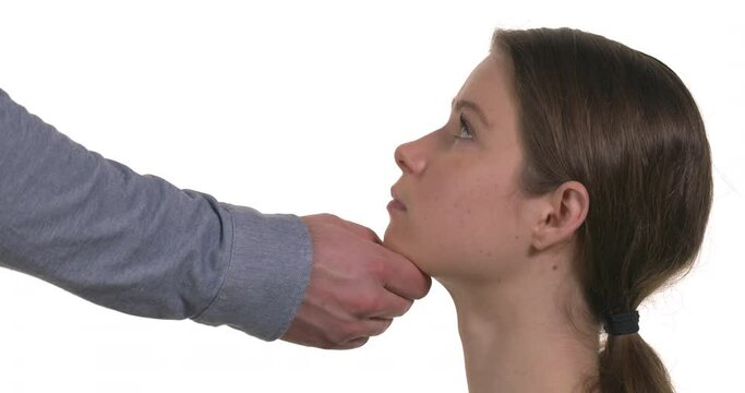 Man is forcing young woman to look at him. Physical harassment concept. Isolated on white background