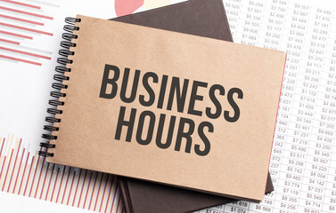 Notepad with text business hours on a charts and numbers. Business concept.