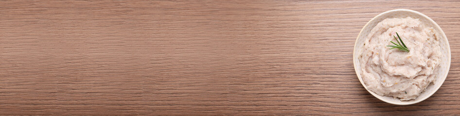 Delicious lard spread in bowl on wooden table, top view. Space for text