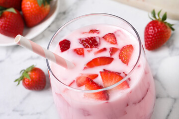 Delicious drink with strawberries on white marble table, closeup