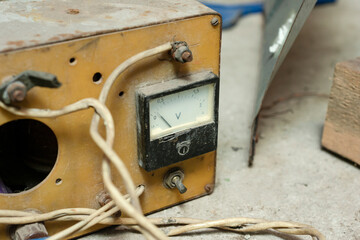 A close-up of an old non-working voltage transformer is lying in the garage.