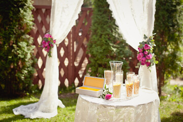 Details of wedding ceremony and tradition of making family amulet from different grain, outdoor. Peony decorations in the wedding celebration