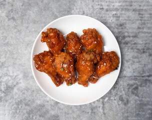 Top view Korean spicy deep-fried chicken topped white sesame on the gray concrete table, popular street food in Korea.