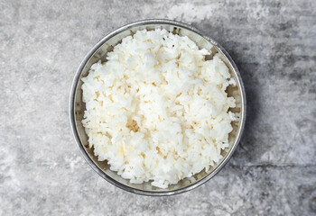 Top view steamed rice in stainless bowl on the gray concrete table.
